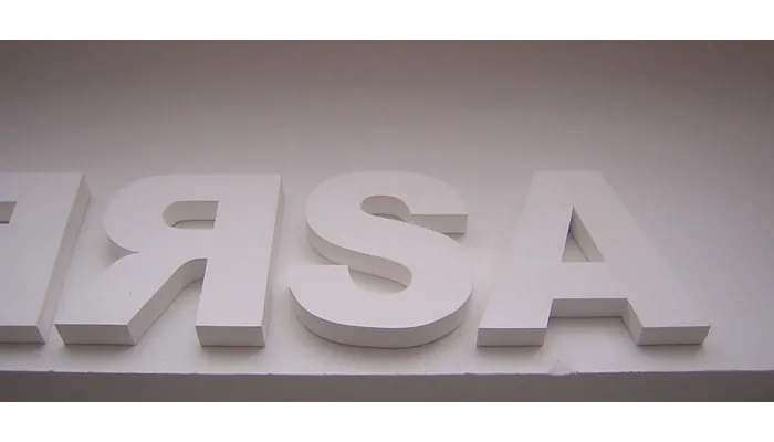 Letras corpóreas blancas sobre pared blanca